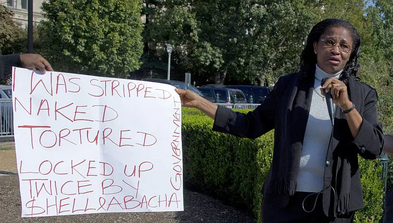 Esther Kiobel, the plaintiff in the lawsuit Kiobel v. Royal Dutch Shell, holds a poster listing abuses she claims she suffered in her native Nigeria as a result of the actions of the Shell Oil Company, outside the Supreme Court building in Washington, D.C., on Oct. 1, 2012. On April 18, 2013, the Supreme Court denied Kiobel’s petition to have her lawsuit against Shell accepted in a U.S. court under the Alien Tort Claims Act, a decision that has narrowed the scope of that statute. (AP Photo/Carolyn Kaster) 