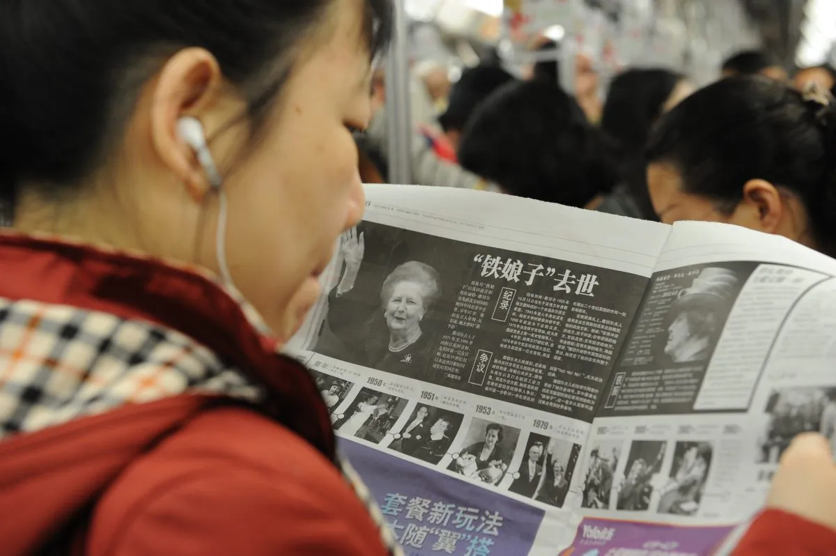 A Chinese woman reads about former British prime minister Margaret Thatcher's death the previous day on April 9, 2013. The Communist Party has now banned use of foreign reports by mainland media. (Peter Parks/AFP/Getty Images)