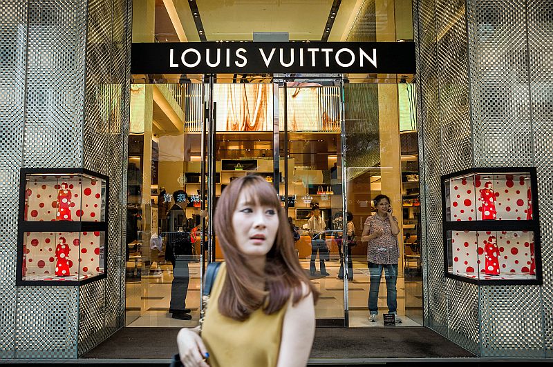 A traveler passes a Louis Vuitton store at Hong Kong International News  Photo - Getty Images