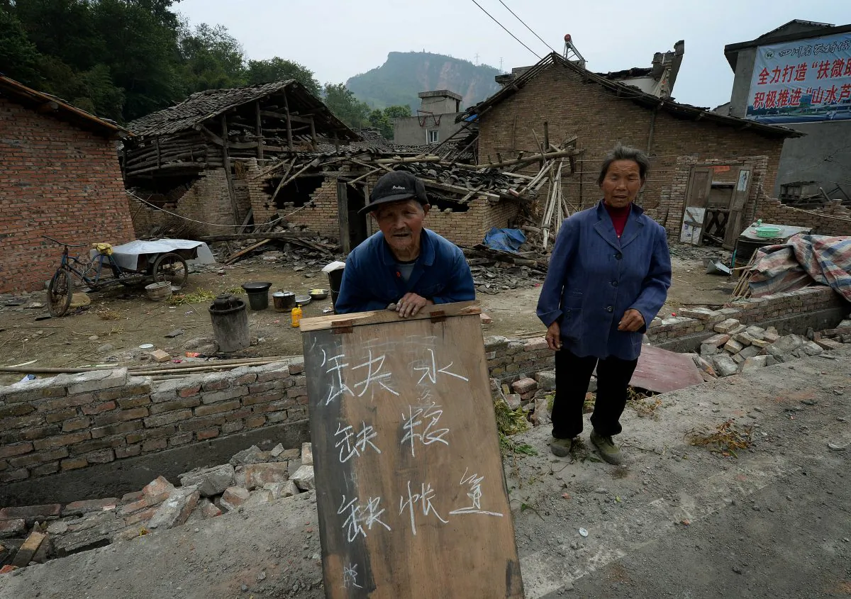 An elderly man holds a sign asking for help outside his destroyed home in Longmen village on April 22, 2013, after a magnitude 7.0 quake hit Sichuan Province on April 20. Two days after the quake, many villagers had not seen official rescue teams, saying they have no water, food, or tents. (Mark Ralston/AFP/Getty Images)