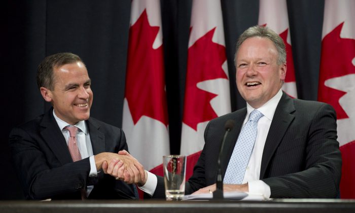 Bank of Canada Governor designate Stephen Poloz (right) shakes hands with outgoing Governor Mark Carney during a news conference in Ottawa, on Thursday, May 2, 2013. (Adrian Wyld/The Canadian Press)