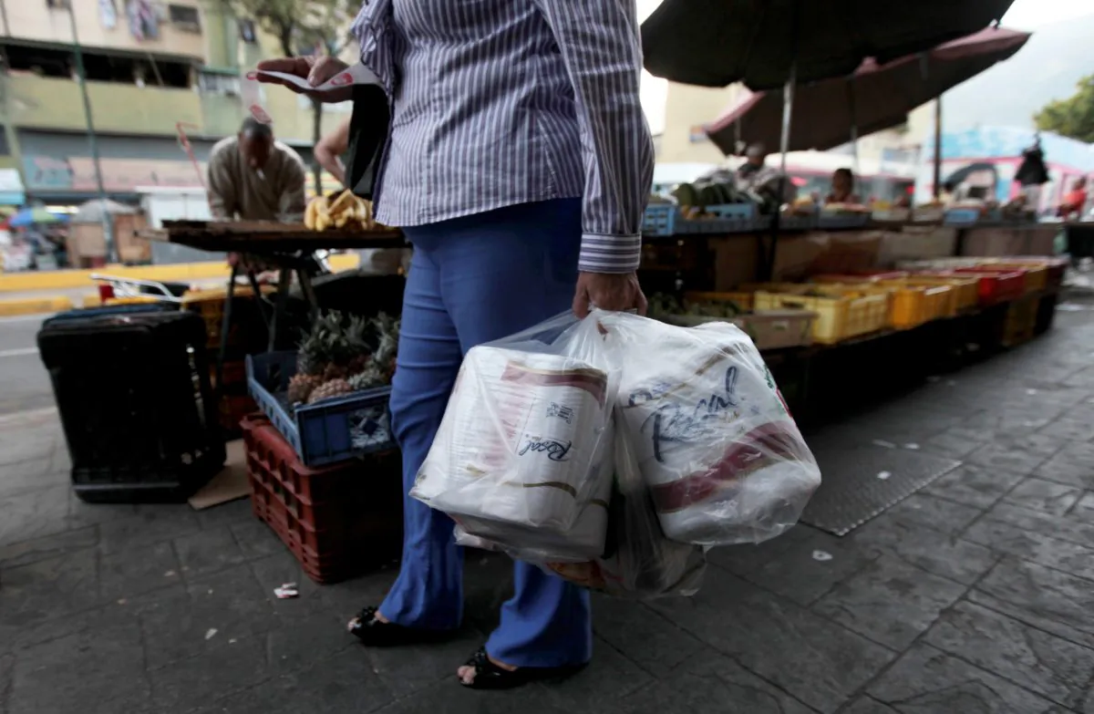 A woman who just bought toilet paper at a grocery store reads her receipt as she leaves the private store in Caracas, Venezuela, on May 15, 2013. First milk, butter, coffee, and cornmeal ran short. Now Venezuela is running out of the most basic of necessities—toilet paper. Economists say Venezuela's shortages stem from price controls meant to make basic goods available to the poorest parts of society and the government's controls on foreign currency. (AP Photo/Fernando Llano)