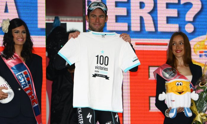 Mark Cavendish of Omega Pharma-Quickstep displays a T-shirt commemorating his 100th professional win after sprinting to victory in Stage Twelve of the 2013 Giro d’Itlia. (omegapharma-quickstep.com)