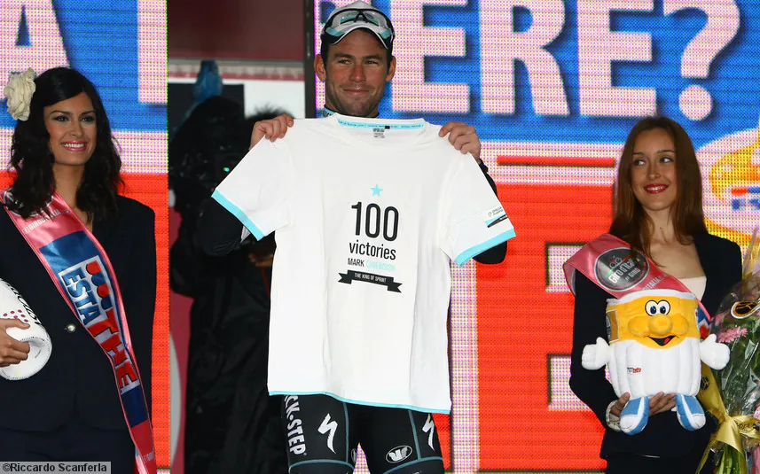 Mark Cavendish of Omega Pharma-Quickstep displays a T-shirt commemorating his 100th professional win after sprinting to victory in Stage Twelve of the 2013 Giro d’Itlia. (omegapharma-quickstep.com)