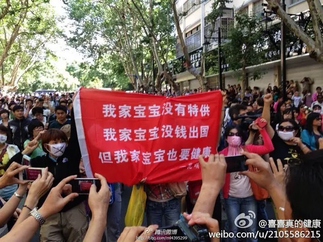 Protesters hold up a banner about pollution, comparing their situation with that of communist officials. "My child doesn't have a special supply of clean air, water or food, my child doesn't have money to go abroad, but my child needs to be healthy too!" (Weibo.com)
This is what saying on the red banner.