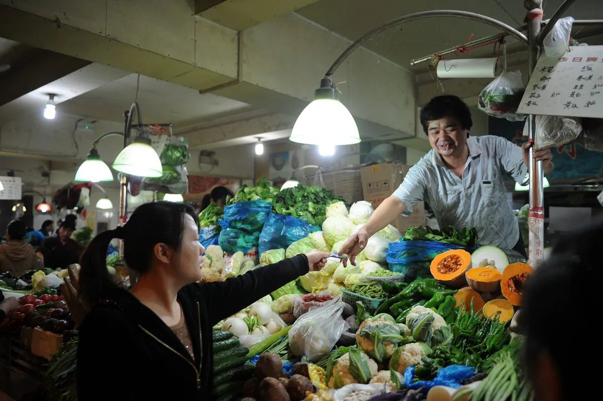 A vendor sells vegetables in a market in Shanghai on Oct. 18, 2012. Prices for inputs are rising across the country, squeezing ordinary Chinese people, according to recent economic statistics and expert analysis. (Peter Parks/AFP/Getty Images)