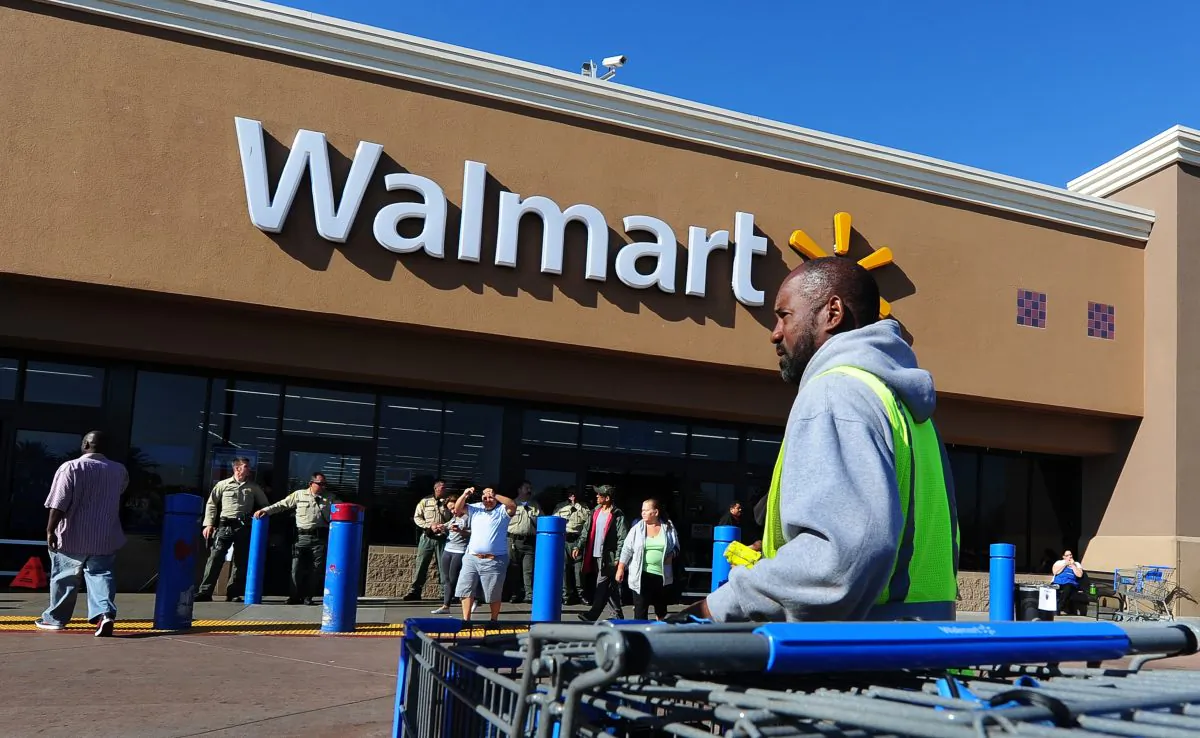 A Walmart employee gathers shopping carts in front of a Walmart store in Paramount, Calif., in 2012 in this file photo. Wal-Mart, the largest U.S. retailer, has been experiencing a slump in sales. (Frederic J. Brown/AFP/Getty Images)