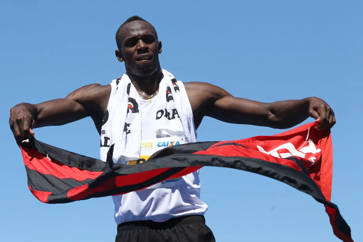 Jamaican runner Usain Bolt waves a flag of Brazilian football club Flamengo at the end of a race in Copacabana Beach in Rio de Janeiro, Brazil, on March 31. Bolt will miss an upcoming race due to a hamstring injury. (Ari Versiani/AFP/Getty Images)