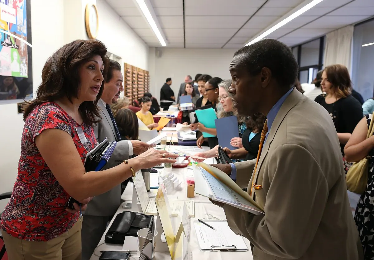 A job seeker (R) meets with a recruiter at an Office of Education job fair on April 24, 2013, in Hayward, Calif. Almost half of America’s college graduates are unable to land a job commensurate with their education. (Justin Sullivan/Getty Images)