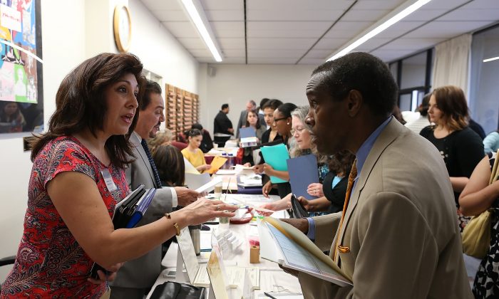 A job seeker (R) meets with a recruiter at an Office of Education job fair on April 24, 2013, in Hayward, Calif. Almost half of America’s college graduates are unable to land a job commensurate with their education. (Justin Sullivan/Getty Images)