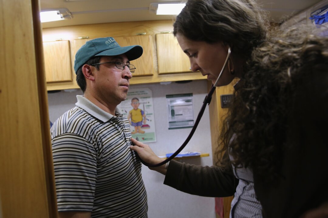A physician's assistant checks the heart rate of a patient on April 30, 2013. Urgent care clinics alleviate the glut of anxious patients in ER waiting rooms and provide them with efficient care. (John Moore/Getty Images)