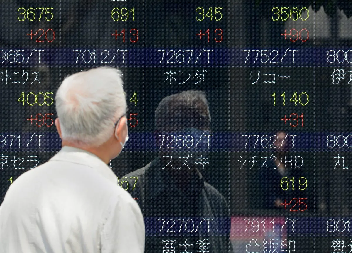 Pedestrians walk past an electric quotation board displaying the Nikkei key index of the Tokyo Stock Exchange (TSE) in front of a securities company in Tokyo on May 10, 2013. (Toru Yamanaka/AFP/Getty Images)