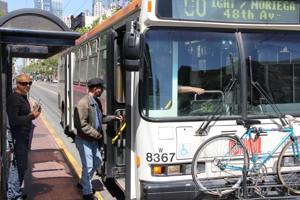 Passengers board a Muni bus on Market Street in San Francisco, Calif., May 28, 2013. (Christian Watjen/The Epoch Times)