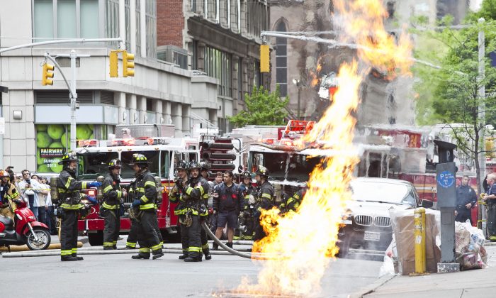 A fire on the NW corner of 6th Avenue and 25th St., next to Two Bros Pizza in Midtown Manhattan, was raging out of a manhole between 5:00 p.m. and 6:00 p.m. (Samira Bouaou/The Epoch Times)