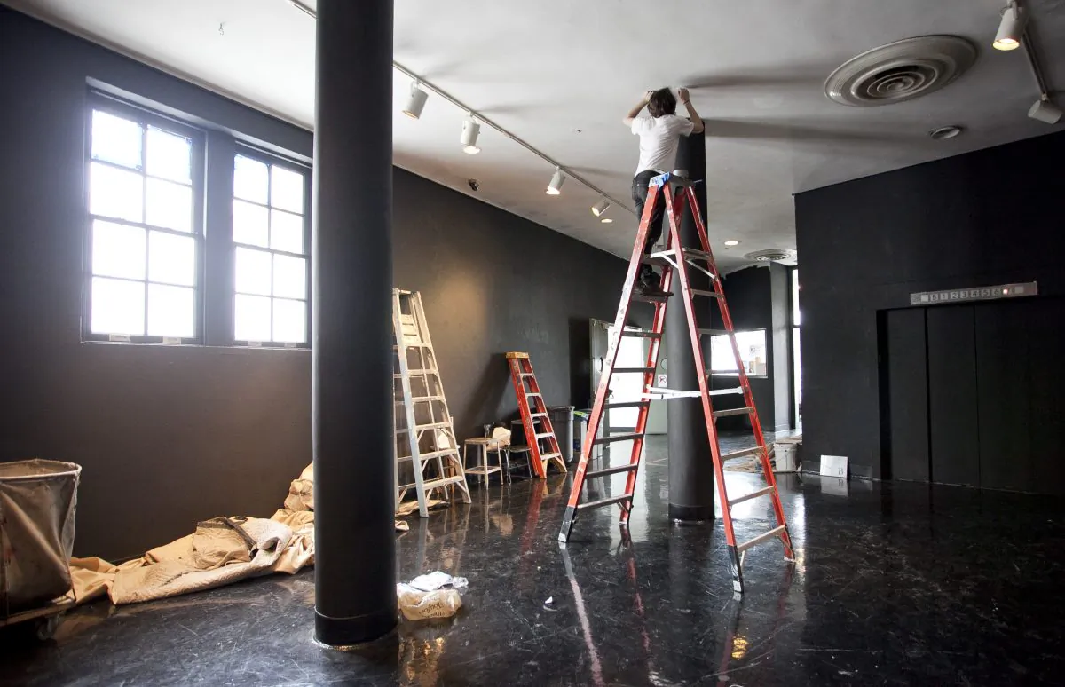 Ralph Singleton stands on a ladder of the seventh floor hallway of The Foundation Building at Cooper Union on May 15. Students painted the walls and pillars black in protest of the college’s decision to institute tuition beginning in the fall of 2014 for the first time since 1859. (Samira Bouaou/The Epoch Times)