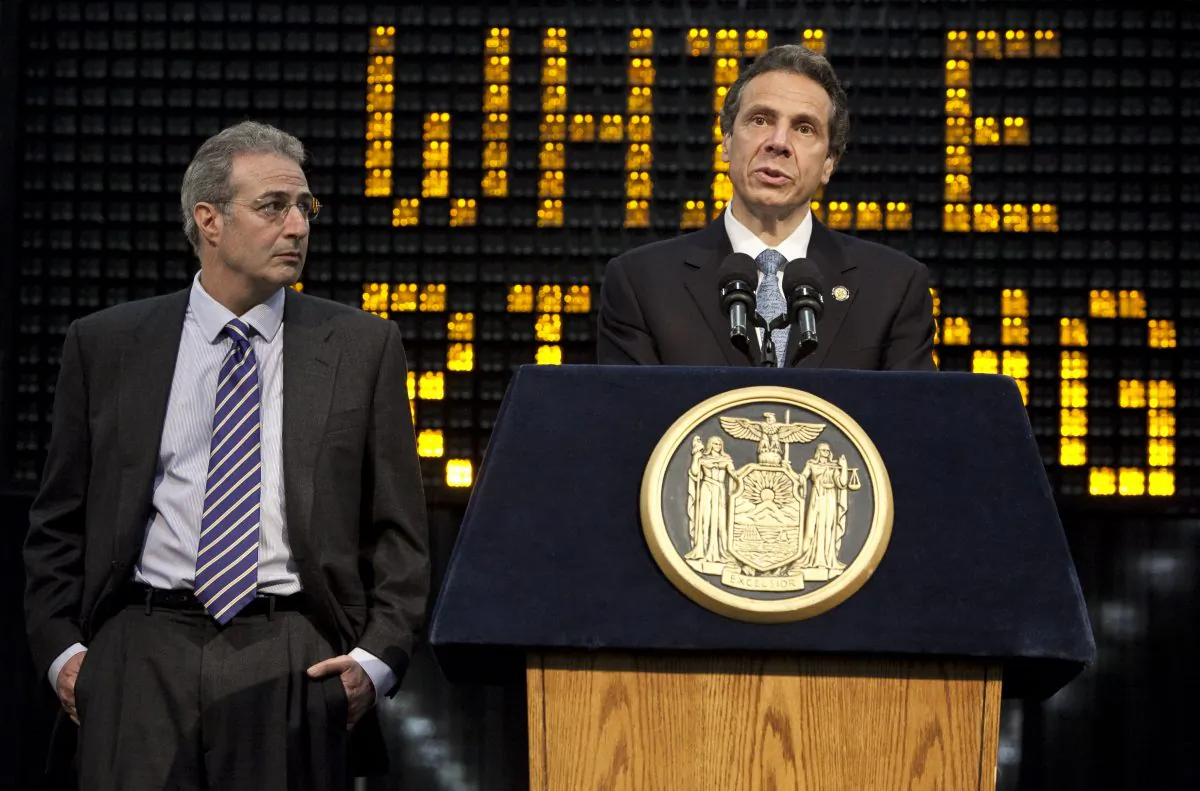 Governor Andrew Cuomo addresses the media about tougher penalties for texting while driving in New York State at the Javitts Center in New York City. Ben Lieberman (left), who lost his son Evan in a car accident involving an driver who was texting while driving, listens on. (Samira Bouaou/The Epoch Times)