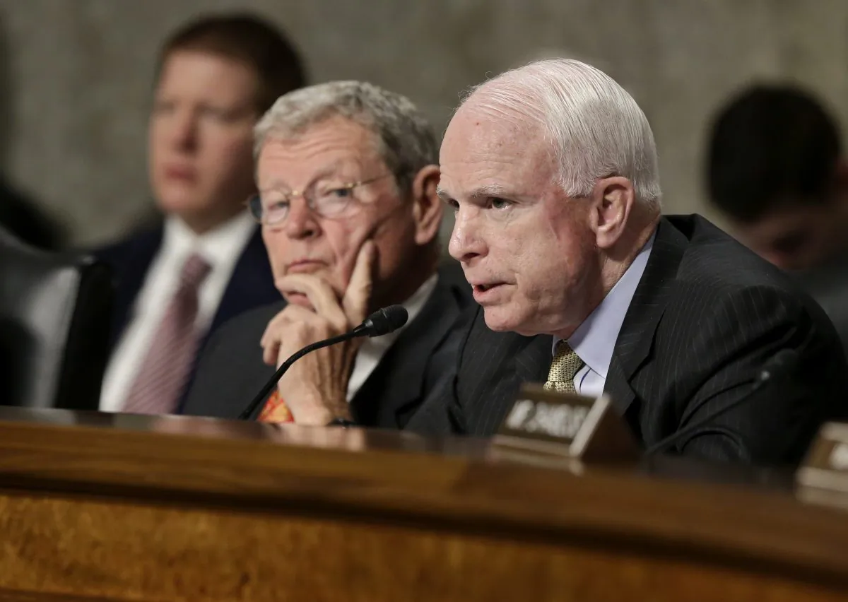 FILE - In this Feb. 7, 2013, file photo, Senate Armed Services Committee member Sen. John McCain, R-Ariz., right, questions Defense Secretary Leon Panetta and Joint Chiefs Chairman Gen. Martin Dempsey, on Capitol Hill in Washington. (AP Photo/J. Scott Applewhite)