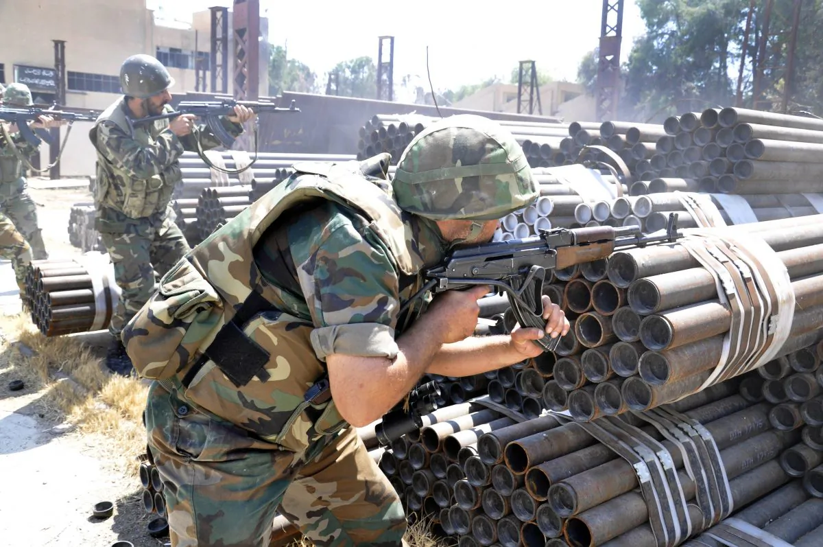 In this photo released on Sunday, May 26, 2013, by the Syrian official news agency SANA, Syrian forces loyal to Syrian President Bashar Assad take their position during a clashes against Syrian rebels, in Aleppo, Syria. (AP Photo/SANA)
