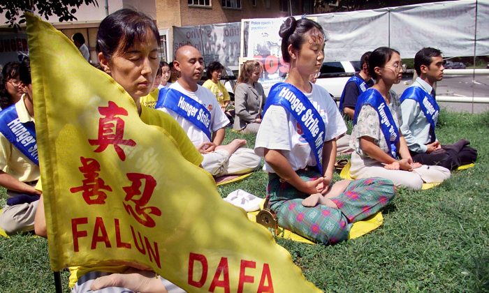 Falun Gong practitioners meditate as they enter their fourth day of a hunger strike in front of the Chinese Embassy in Washington, D.C., on Aug. 20, 2001. The practitioners held the hunger strike to call for the release of 130 practitioners imprisoned at the Masanjia Labor Camp in Liaoning Province of China. (STEPHEN JAFFE/AFP/Getty Images)