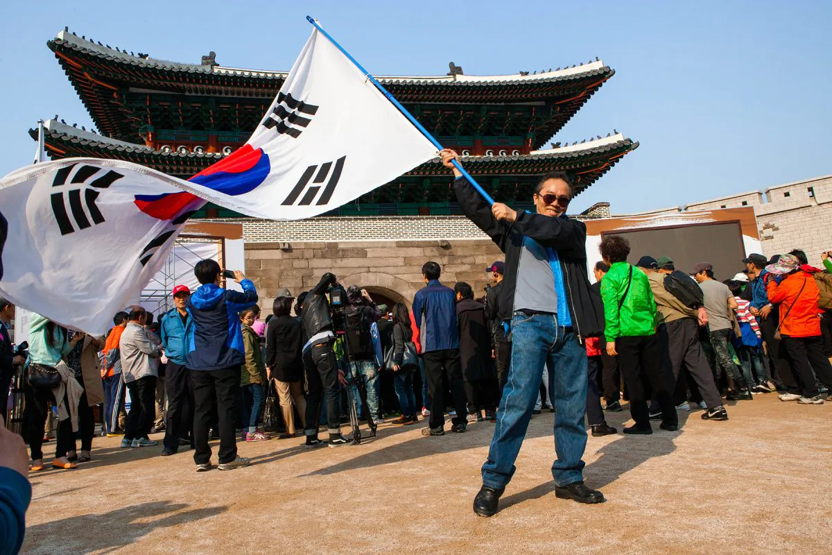 A man waves the South Korean flag in front of Namdaemun on the afternoon of its reopening on May 4, 2013. (Jarrod Hall/The Epoch Times) 
