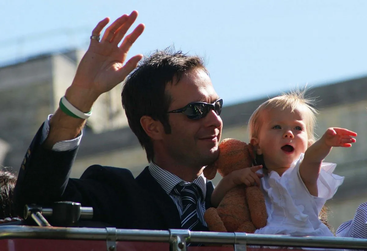 Captain Michael Vaughan and his daughter Talulah Grace wave to the crowd as the England Cricket team enter Trafalgar Square as part of the Ashes victory celebration on September 13, 2005. (Miles Willis/Getty Images)