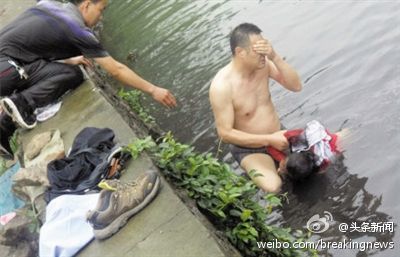 Zhang Guangcong, a policeman, grasps his eyes as he pulls a fourteen-year-old girl from the stinking river water. Zhang was hospitalized, vomiting and dizzy, the day after jumping into the severely polluted river. (Weibo.com)