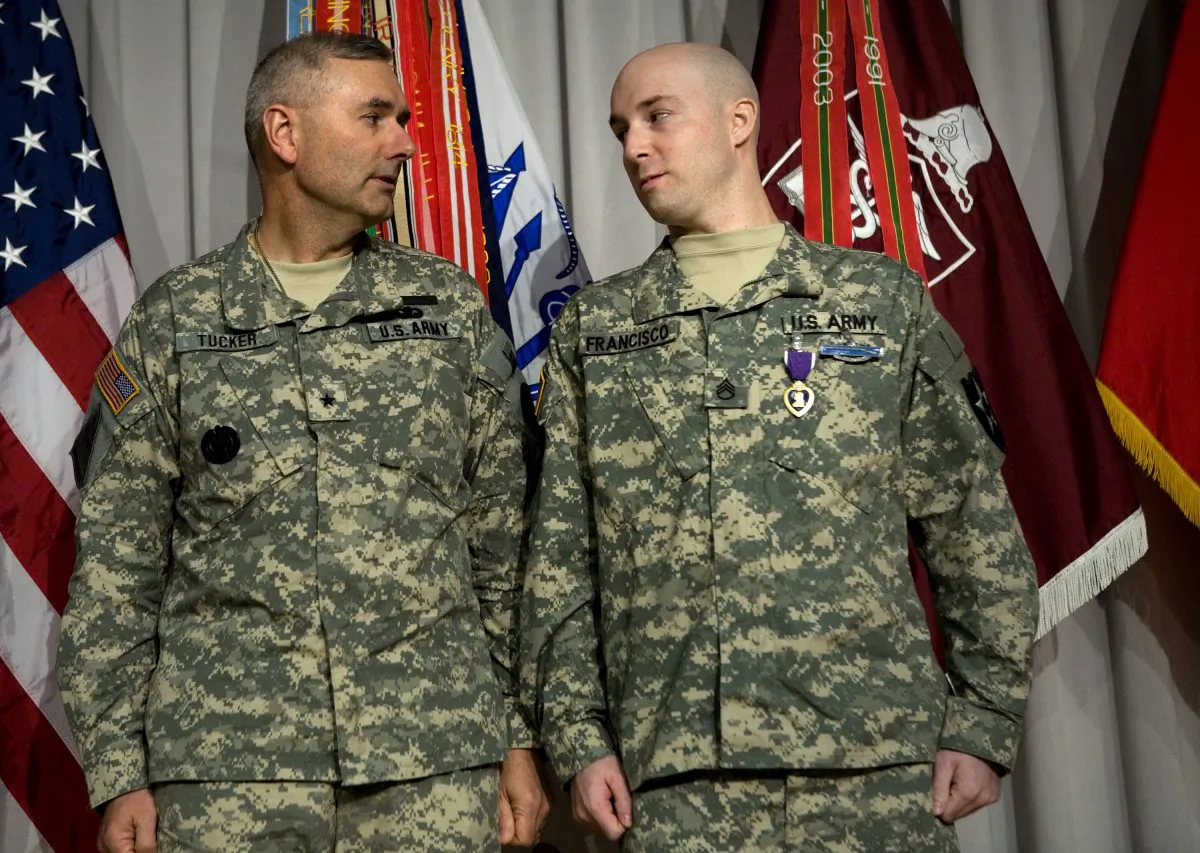 FILE PHOTO: BG Michael Tucker (L) looks at SSG John Francisco III (R) after awarding him the Purple Heart during a Purple Heart ceremony at Walter Reed Army Medical Center April 27, 2007 in Washington, DC. (Brendan Smialowski/Getty Images)
