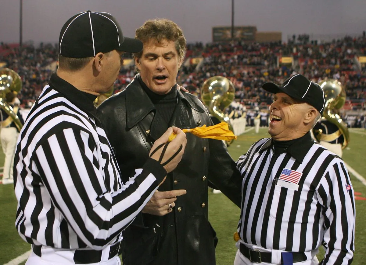 Actor David Hasselhoff (C) jokes with referees Danny Worrell (L) and Tommy Pace (R) before Hasselhoff sang the American national anthem at the Pioneer Las Vegas Bowl featuring Arizona and Brigham Young University at Sam Boyd Stadium December 20, 2008 in Las Vegas, Nevada. His daughter Taylor-Ann Hasselhoff attends Arizona.  (Photo by Ethan Miller/Getty Images)