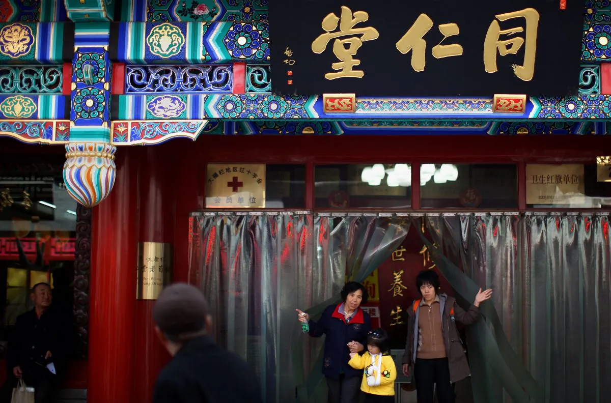 Chinese residents walk out of the Tongrentang drugstore, the famous Chinese traditional medicine drugstore, in an alleyway of the Qianmen area on March 16, 2008 in Beijing, China. (Feng Li/Getty Images) 