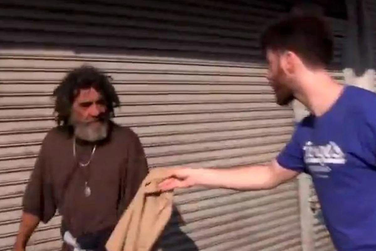 Filmmaker Greg Karber hands a man a piece of Abercrombie & Fitch clothing in East Los Angeles in a video posted to YouTube on May 13, 2013. (Screenshot/YouTube)