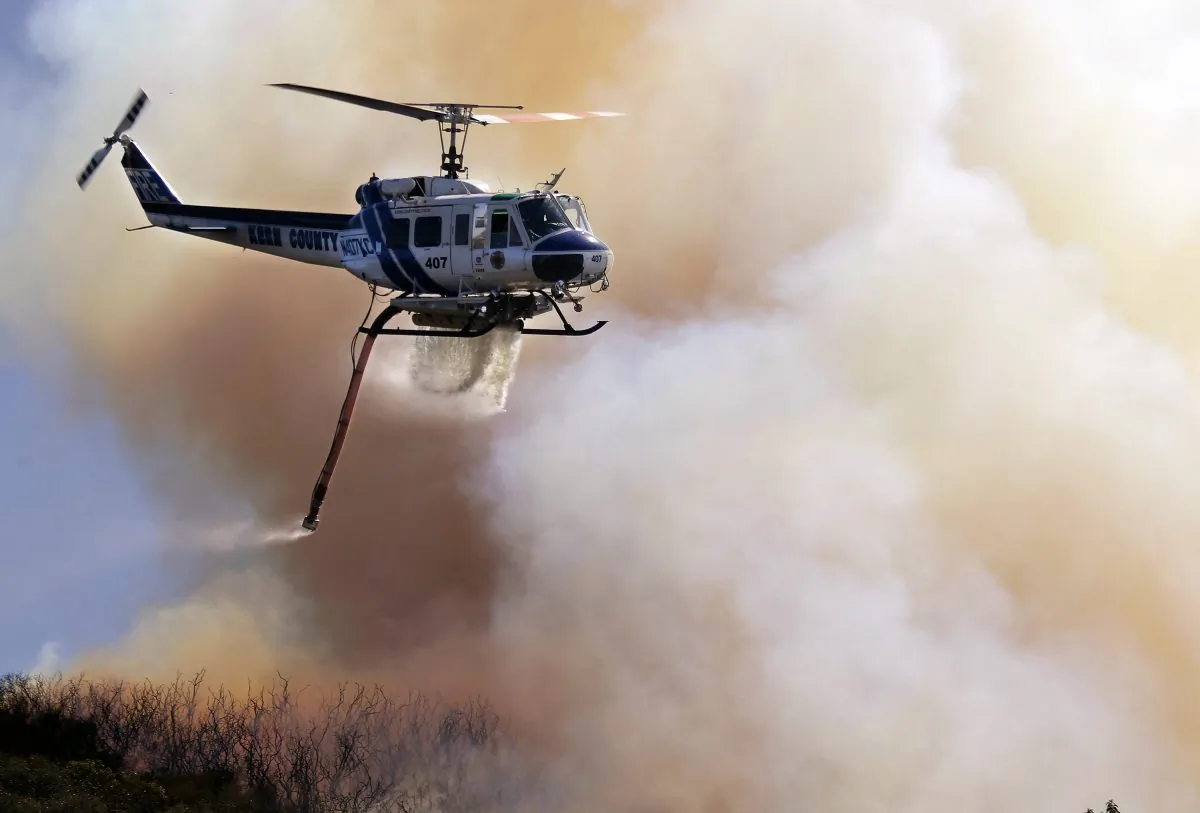 A fire helicopter makes a water drop on a hotspot over a hill near Thousand Oaks, Calif. in this file photo. A wildfire near Santa Barbara caught thousands of campers off-guard and forced their evacuation May 27. (AP Photo/Nick Ut)