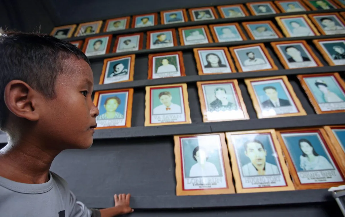 File photo of a Cambodian orphan, Chang Saron, 8, looking at portraits of AIDS victims at the NGO Partners in Compassion Cambodia (PCC) in Takeo Province, some 45 kilometers south of Phnom Penh (Tang Chhin Sothy/AFP/Getty Images)