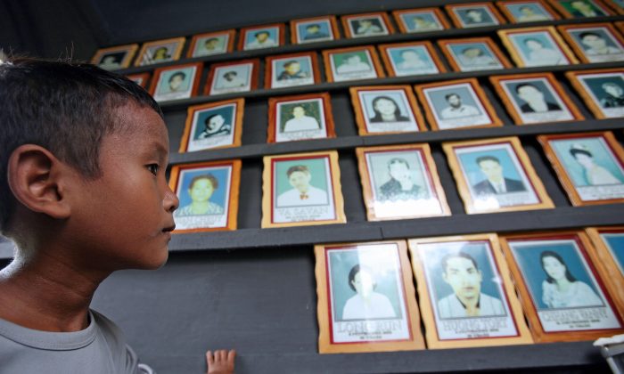 File photo of a Cambodian orphan, Chang Saron, 8, looking at portraits of AIDS victims at the NGO Partners in Compassion Cambodia (PCC) in Takeo Province, some 45 kilometers south of Phnom Penh (Tang Chhin Sothy/AFP/Getty Images)