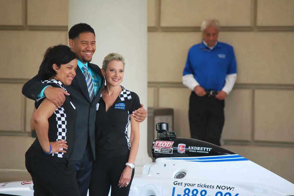 Thais Jackson and Kathy Flick with the Baltimore Grand Prix John S. Holt III pose for a photo with an IZOD Indy Car Series car at the MD. Washington Minority Companies Association Spring Breakfast and business expo in Balitore on May 10. (Ron Dory/The Epoch Times)