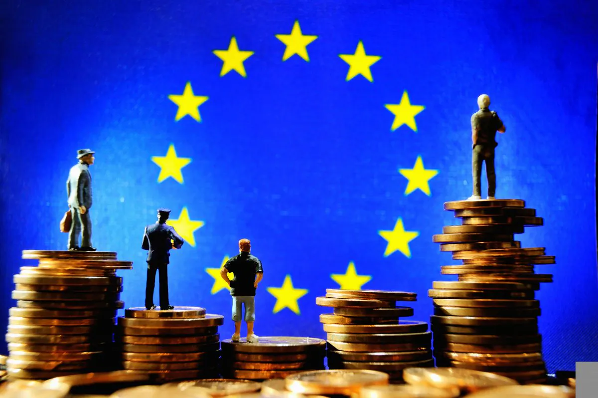 An illustration with figurines set up on euro coins in front of the European Union flag. (Philippe Huguen/AFP/Getty Images)