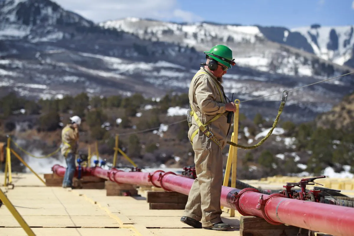 In this March 29 photo, a worker helps monitor water pumping pressure and temperature, at the site of a natural gas hydraulic fracturing and extraction operation run by Encana Oil & Gas (USA) Inc., outside Rifle, Colo. (AP Photo/Brennan Linsley)