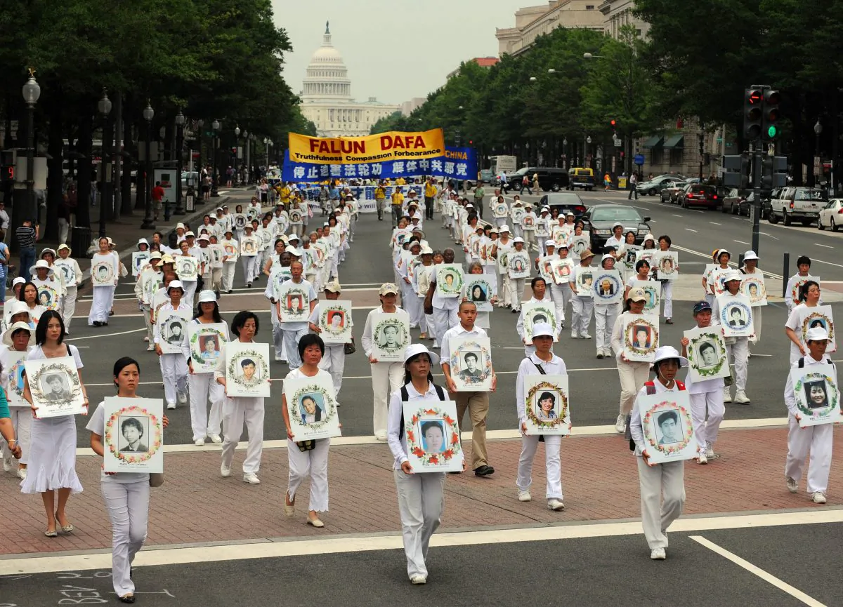Falun Gong practitioners dressed in white carry pictures of adherents of the spiritual discipline killed in China during the persecution launched by former Communist Party head Jiang Zemin, in Washington, D.C. on July 17, 2009. A recent decision by an Argentine court holds open the possibility that a 2009 ruling by an Argentine court to arrest Jiang Zemin for human rights violations, which had been overturned on appeal, may be reinstated. (TIM SLOAN/AFP/Getty Images)