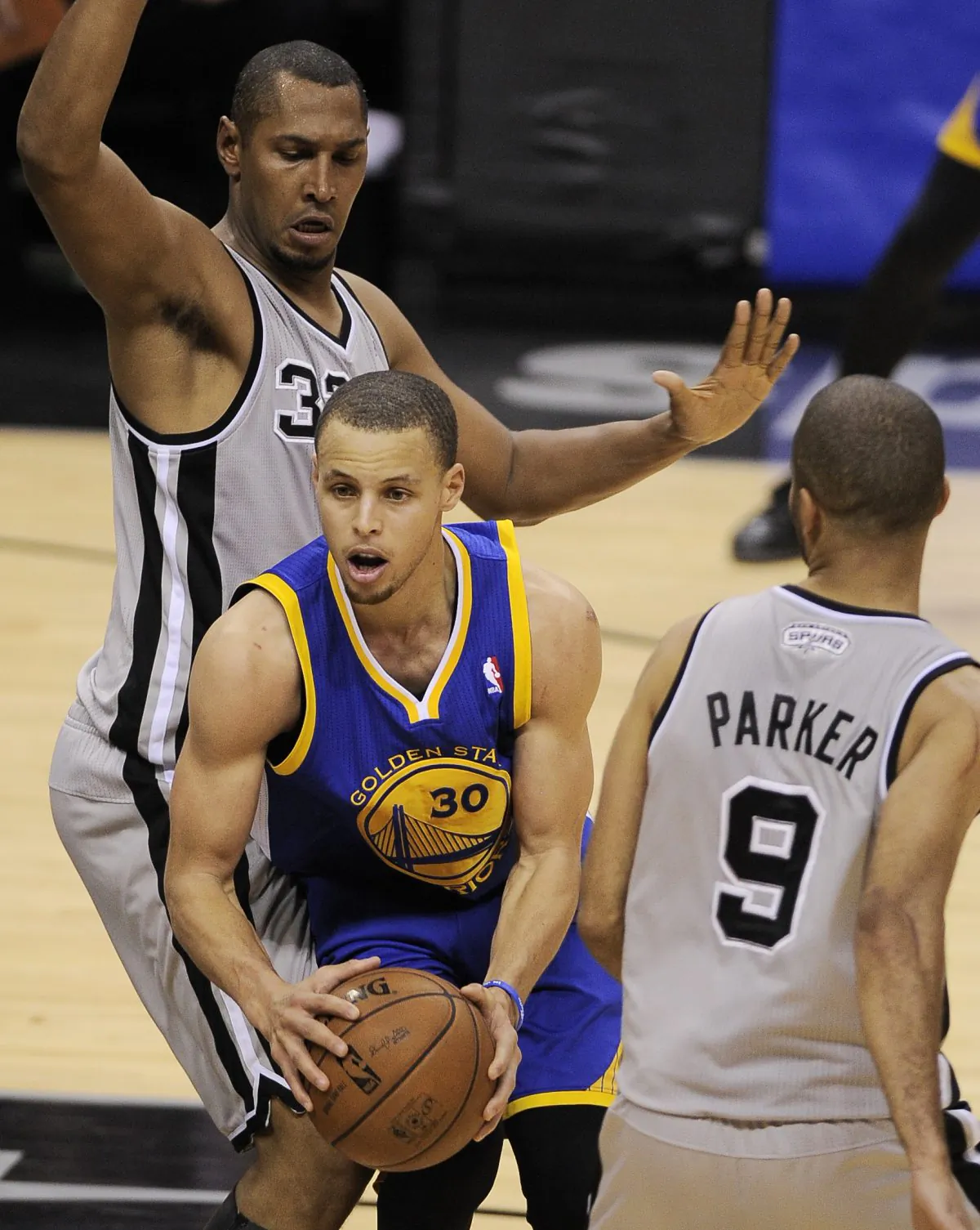 Golden State Warriors' Stephen Curry (C) drives between San Antonio Spurs' Tony Parker, right, of France, and Boris Diaw, of France, during the second half of Game 1 of the Western Conference semifinal NBA basketball playoff series in San Antonio on Monday, May 6, 2013. San Antonio won 129-127 in double overtime. (AP Photo/Darren Abate)