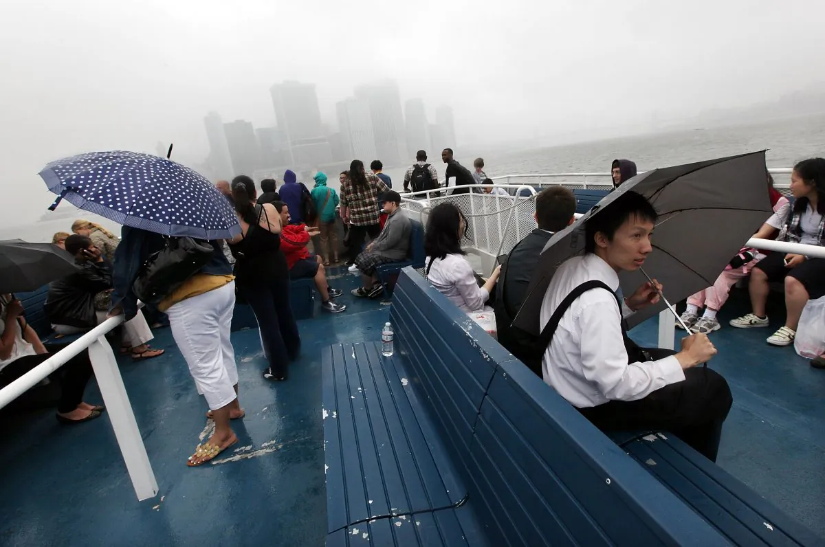 Riders depart on a ferry in the rain from Figment NYC, a free public art event on Governors Island, with the Manhattan skyline in the background on June 11, 2011 in New York City. Governors Island will open for the 2013 season on Memorial Day weekend. (Mario Tama/Getty Images)