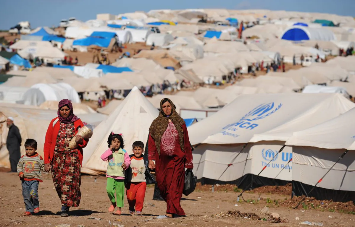 Syrian internally displaced people walk in the Atme camp, along the Turkish border in the northwestern Syrian province of Idlib, on March 19, 2013. (Bulent Kilic/AFP/Getty Images)