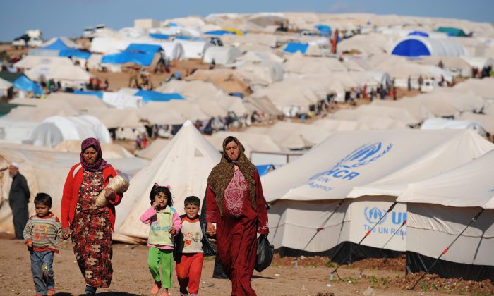 Syrian internally displaced people walk in the Atme camp, along the Turkish border in the northwestern Syrian province of Idlib, on March 19, 2013. (Bulent Kilic/AFP/Getty Images)