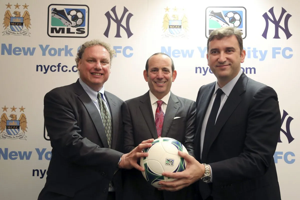 New York Yankees president Randy Levine, left, Major League Soccer Commissioner Don Garber, center, and Manchester City CEO Ferran Soriano pose for a photo at the MLS headquarter in New York, Tuesday, May 21, 2013. The New York Yankees are partnering with Manchester City to own Major League Soccer's 20th team, which will be called New York City Football Club and plans to start play in the 2015 season. (AP Photo/Mary Altaffer)
