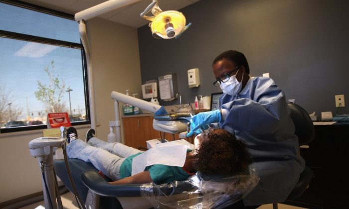 Registered dental hygienist Denise Lopez-Rodriguez cleans teeth at a community health center in Aurora, Co., in March. (John Moore/Getty Images)