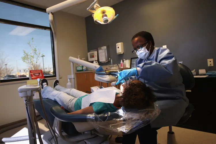 Registered dental hygienist Denise Lopez-Rodriguez cleans teeth at a community health center in Aurora, Co., in March. (John Moore/Getty Images)