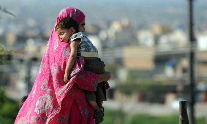 A Pakistani woman carries her son as she walk on a street in Islamabad on May 13, 2012, on Mother's Day. (Farooq Naeem/AFP/GettyImages)