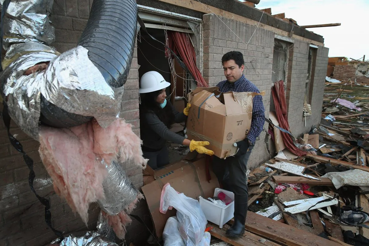 Ofelia Olivera (L) and Oscar Ruiz help to salvage items from a friend's home after a powerful tornado ripped through the area in Moore, Okla., on May 21, 2013. (Scott Olson/Getty Images)