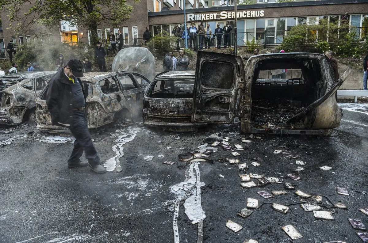 A bystander checks the debris of a burnt out cars in the Stockholm suburb of Rinkeby after youths rioted in several different suburbs around Stockholm, Sweden, for a fourth consecutive night on May 23, 2013. In the suburb of Husby, where the riots began on Sunday in response to the fatal police shooting of a 69-year-old machete-wielding man, 80 percent of residents are immigrants and the unrest has highlighted Sweden's failure to integrate swathes of its immigrant population. (Fredrik Sandberg/AFP/Getty Images) 