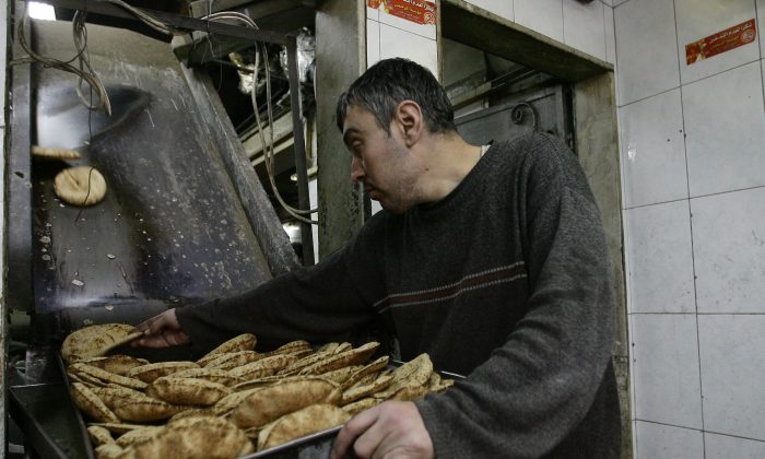 An employee puts pastries on a tray at a bakery in the Syrian capital Damascus on March 7, 2013. The nation's bakeries have lost a total of more than $3.5 million since the civil war began. (Louai Beshara/AFP/Getty Images)