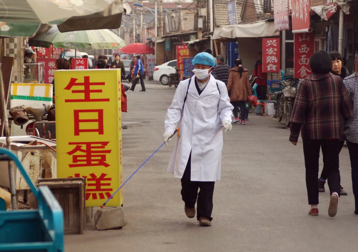 A health worker sprays disinfectant near the house of a 4-year-old boy infected with the H7N9 strain in Beijing on April 15, 2013. New research shows that the H7N9 bird flu virus spreads between ferrets in close contact with each other, suggesting human-to-human transmission is possible. (ChinaFotoPress/Getty Images)