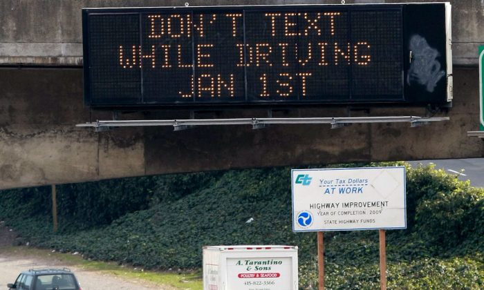 Cars drive on Interstate 280 by a notification of a texting while driving law in San Francisco, Calif. on Dec. 29, 2008. A survey published May 5, 2013, shows many such laws in the United States are not being enforced. (Justin Sullivan/Getty Images)